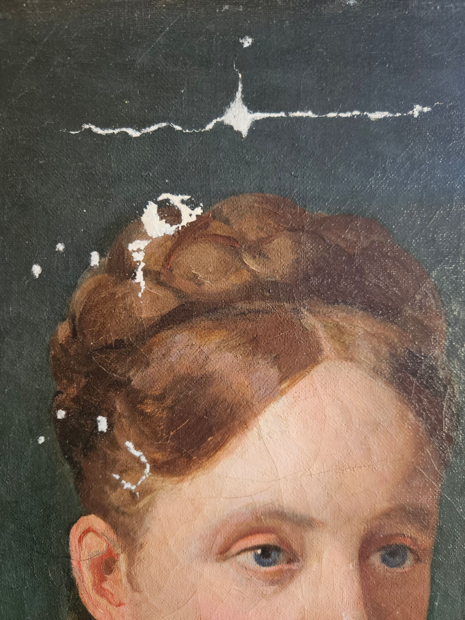 Zone de la tête d'un tableau de femme avec des manques de peinture.