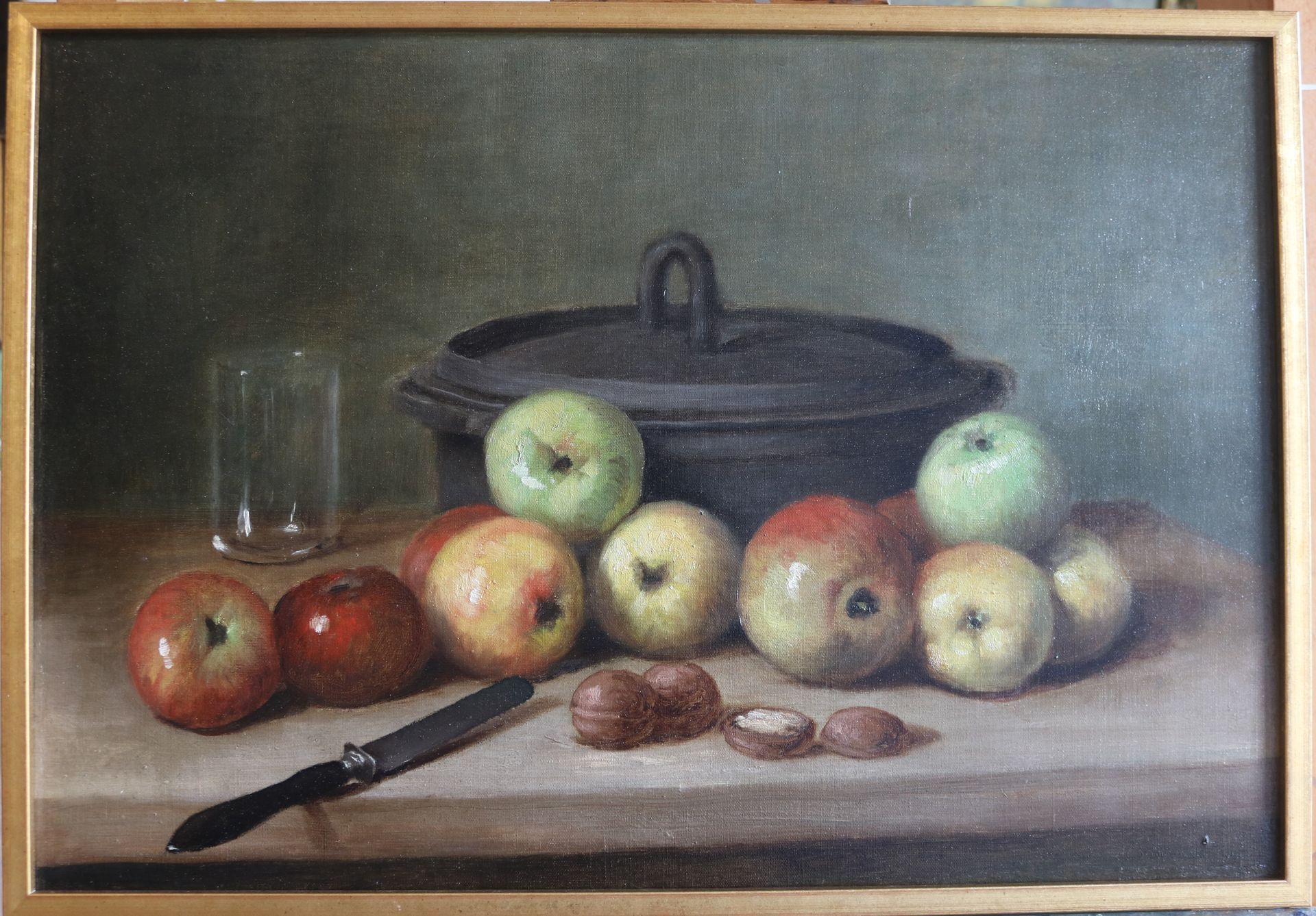 Tableau d'une cocotte en fonte avec des pommes, un verre et des noix
