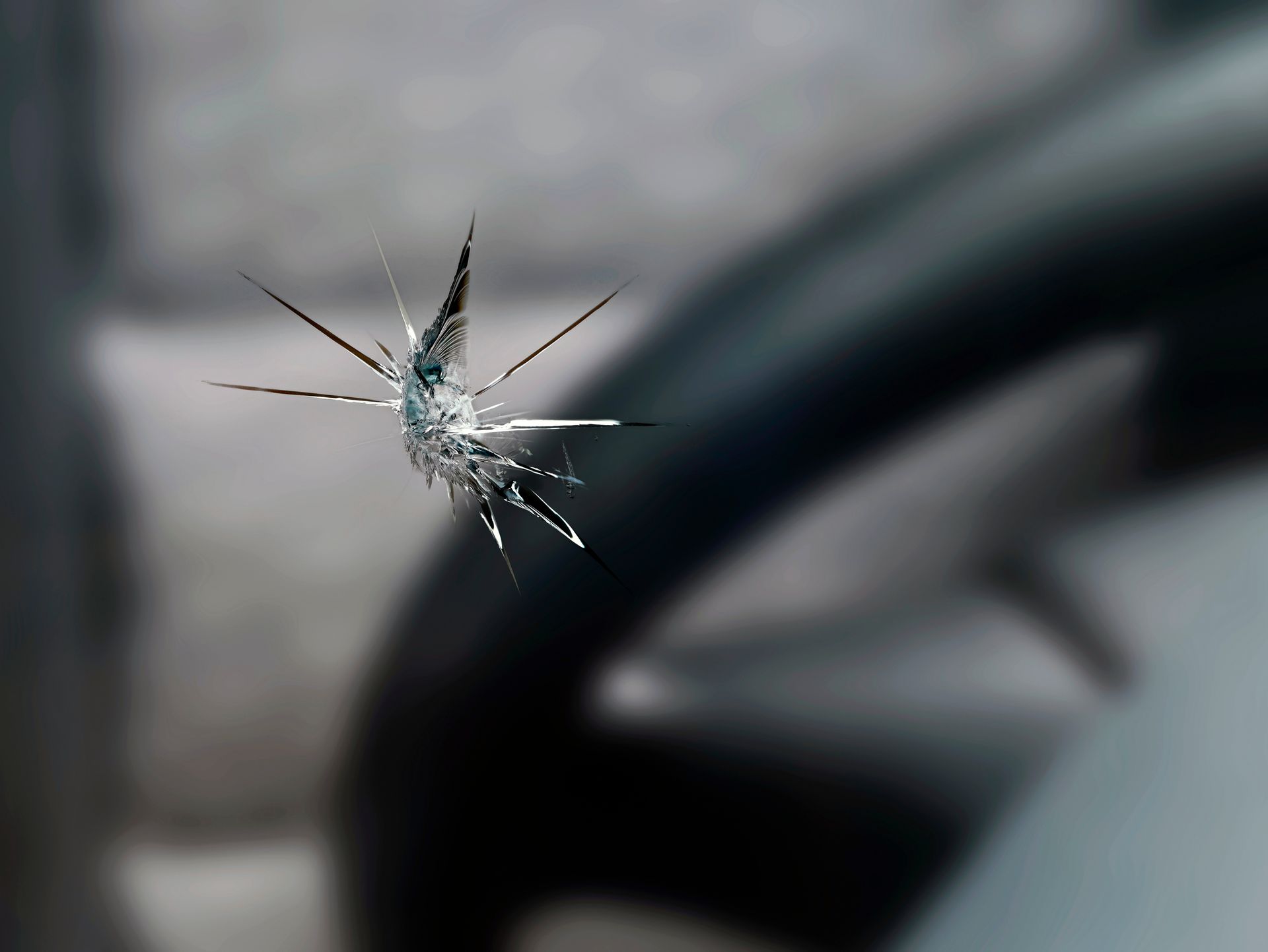 Verre brisé avec un impact en forme d'étoile, fond sombre flou.