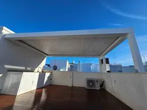 Hay una pérgola en el tejado de un edificio.