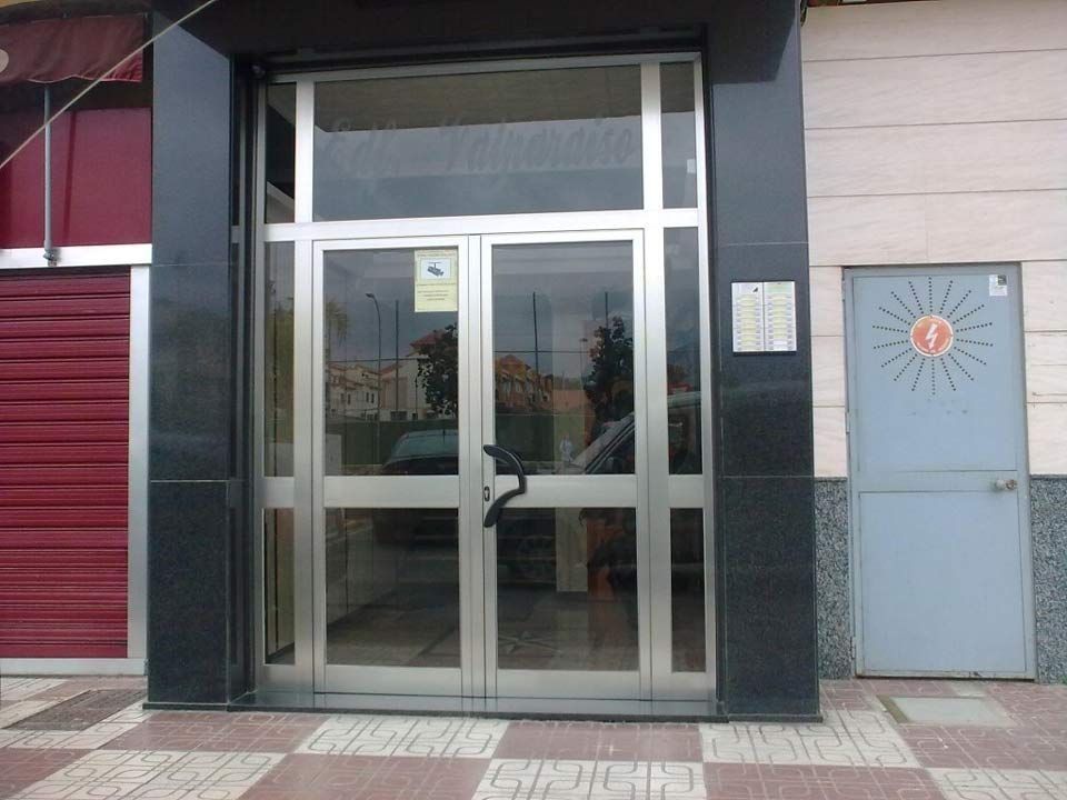 Una puerta de acero inoxidable con un sol encima.