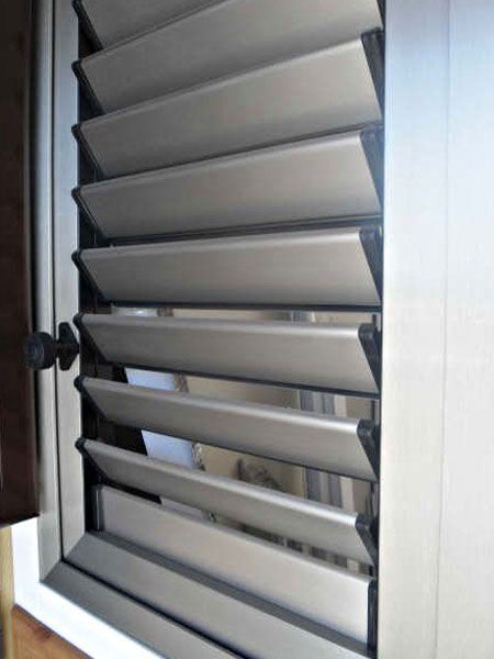 Un primer plano de una ventana con persianas de aluminio.
