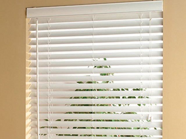Un primer plano de una persiana blanca en una ventana.