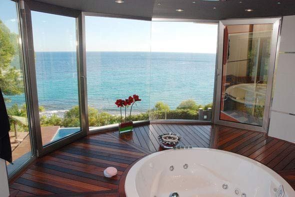 Un baño con bañera de hidromasaje y vista al mar.