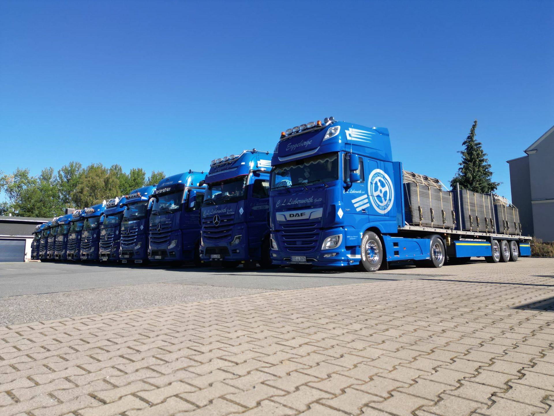 Eine Reihe blauer Lastwagen parkte entlang einer breiten Straße unter einem bewölkten Himmel