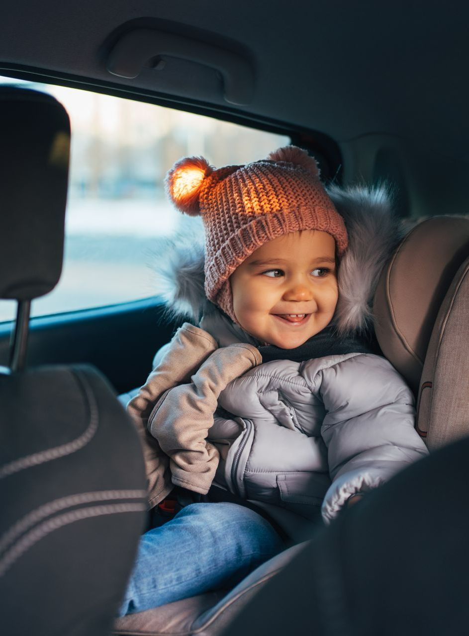 Une enfant dans un siège auto à l'arrière d'une voiture 