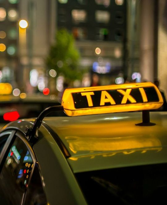 Enseigne TAXI allumée au-dessus d'une voiture