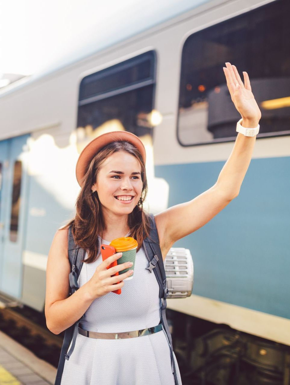 Femme lève le bras à côté d'un train