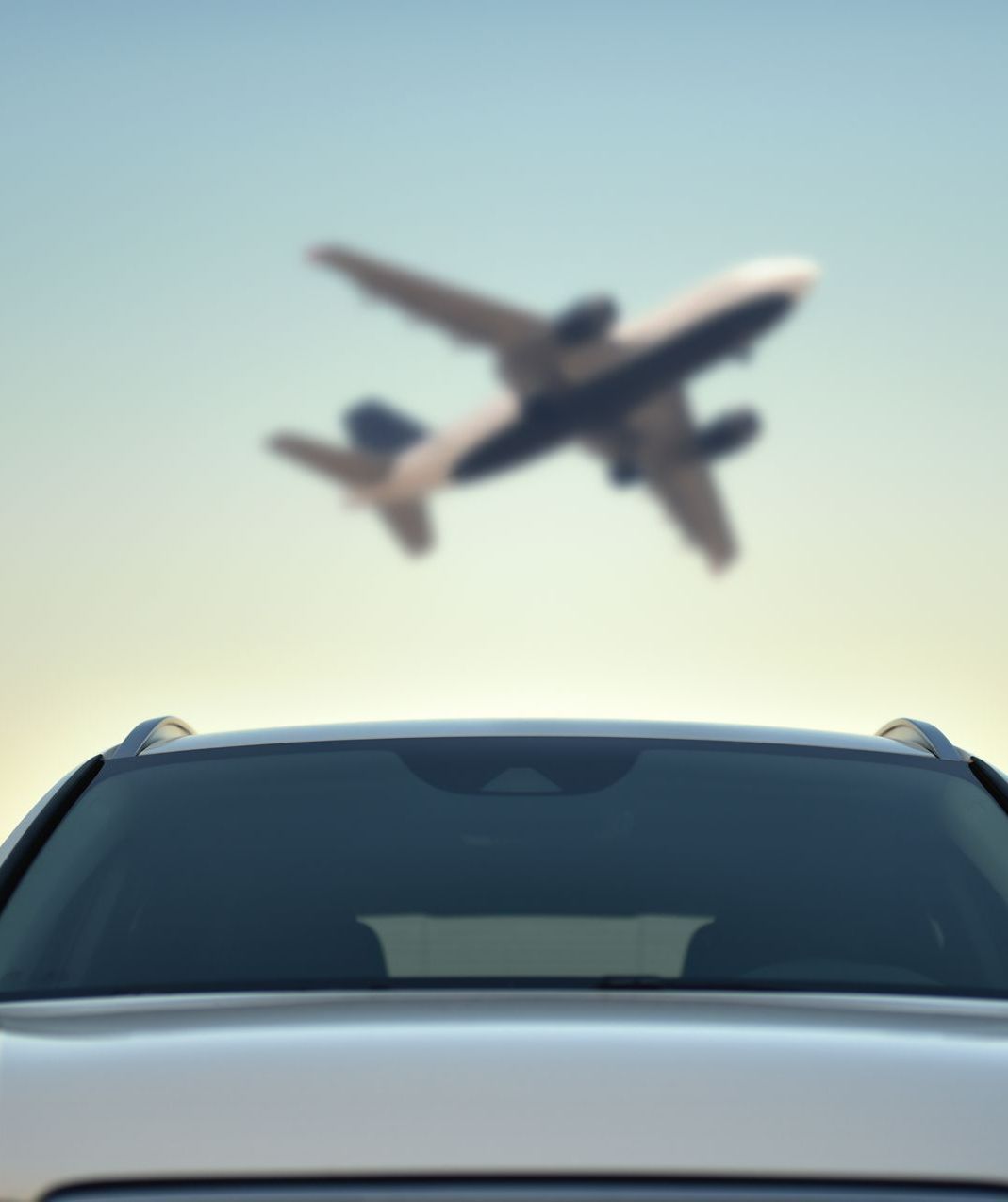 Voiture avec un avion plus haut dans le ciel