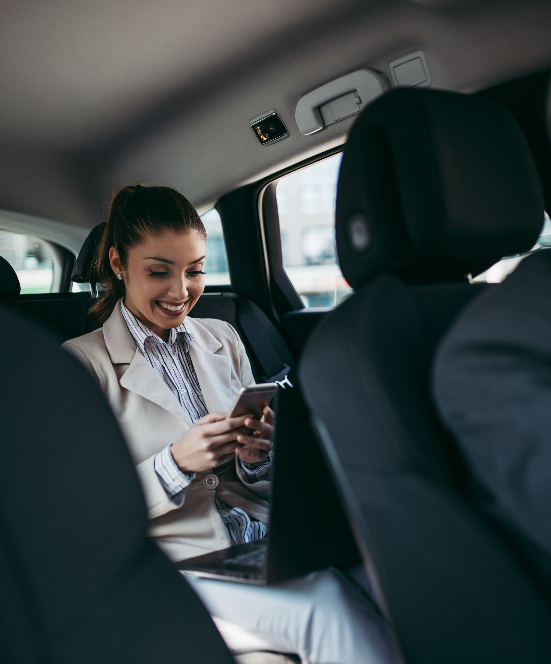 Une femme avec son téléphone à l'arrière d'un taxi