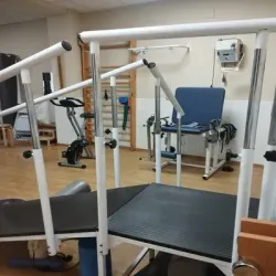 Un gimnasio lleno de equipos de ejercicio, incluida una cinta de correr.