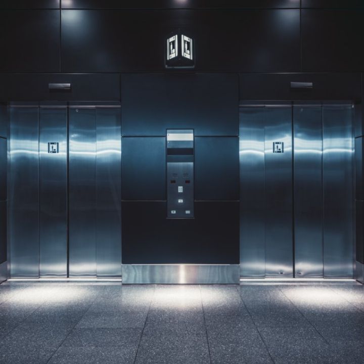 Una fila de ascensores en un edificio con un cartel que dice dg