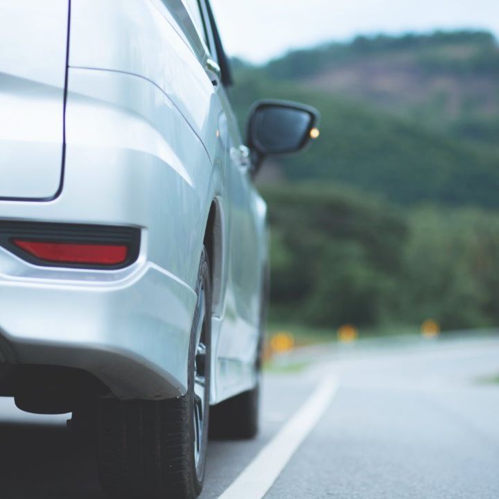 Un coche blanco está aparcado al costado de la carretera.