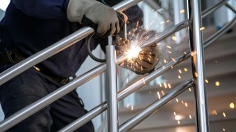 Une personne effectuant une soudure sur un garde-corps en métal.