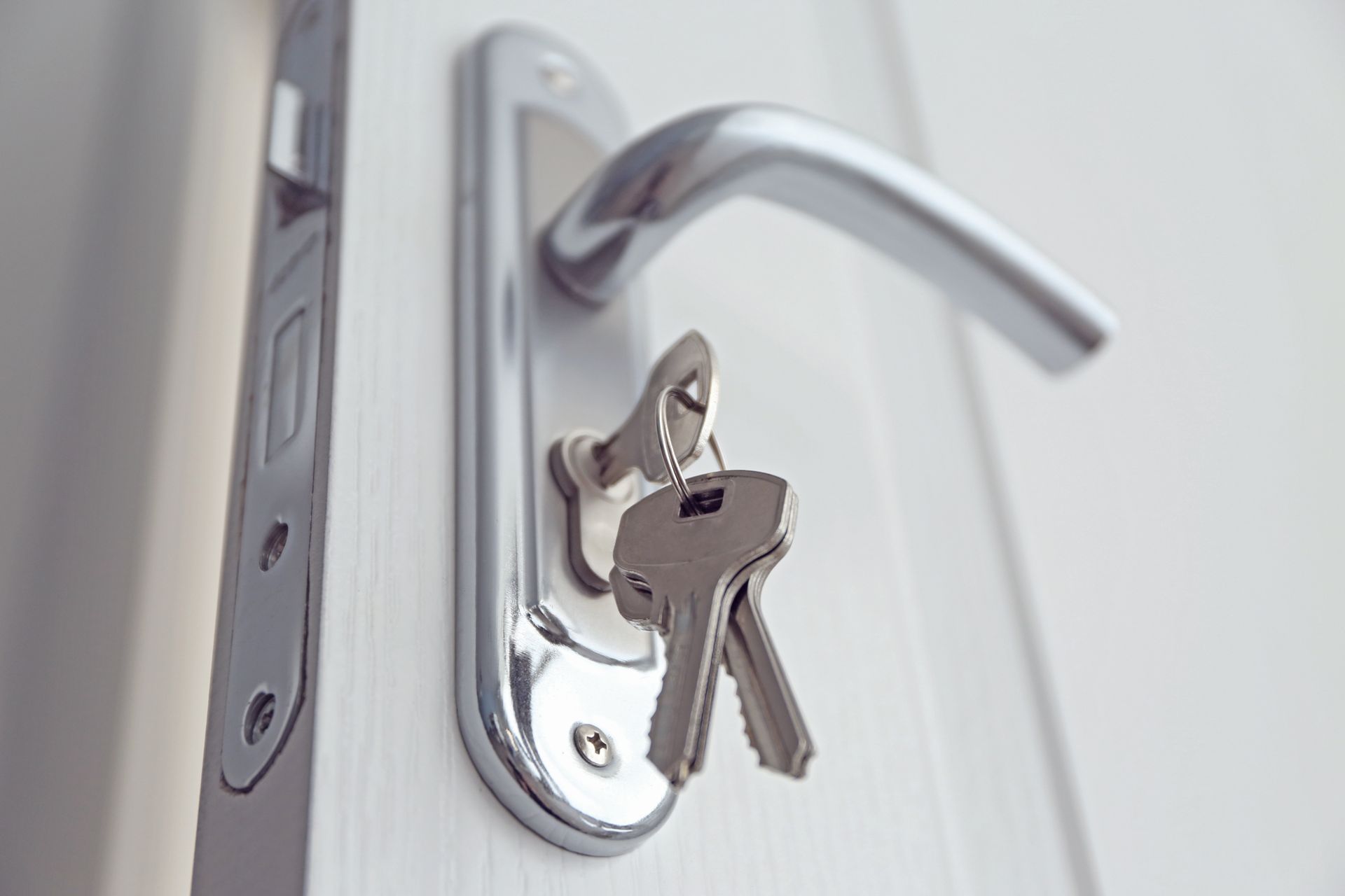 Une clé dans une porte blanche.
