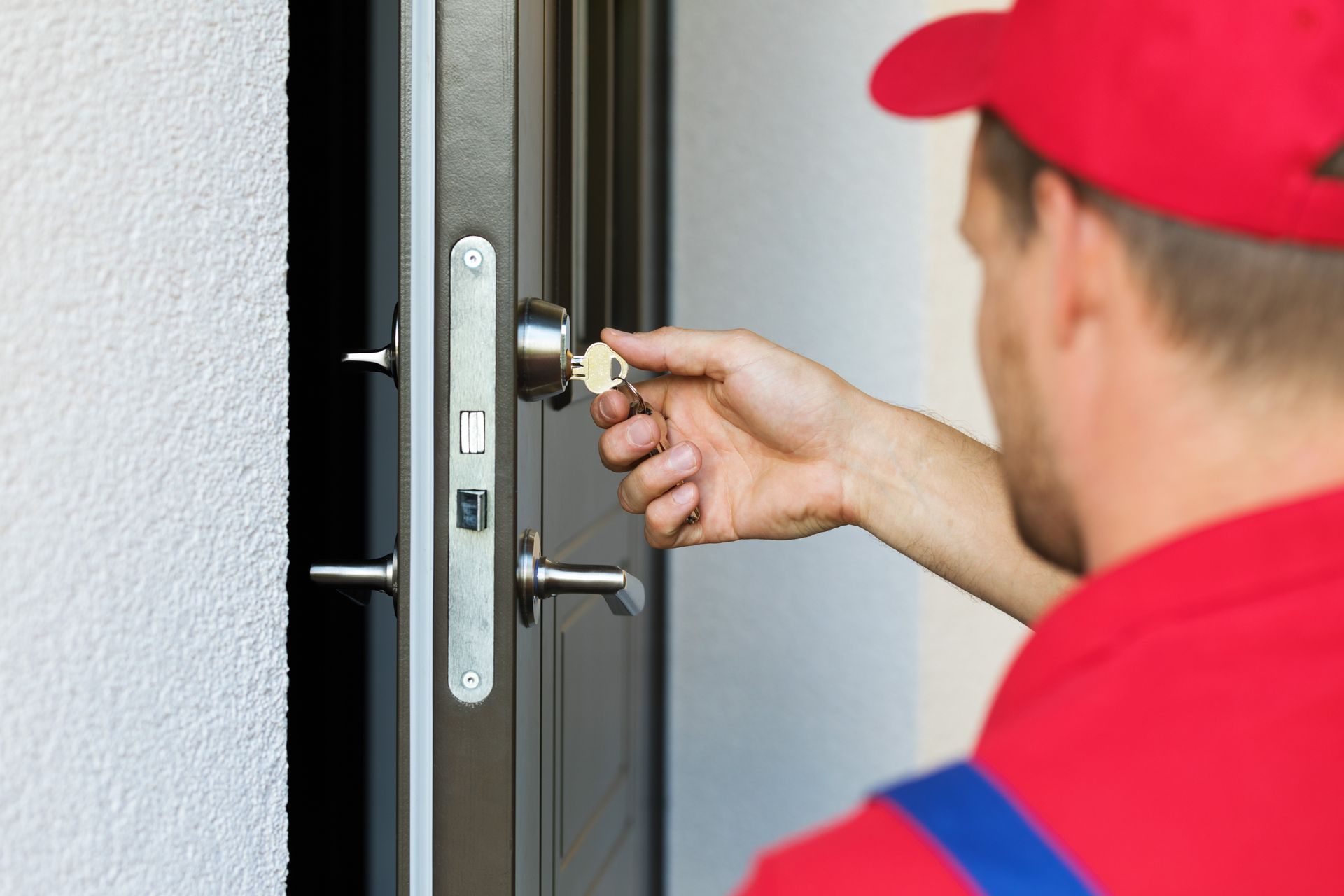 Une personne en train de tourner une clé dans une porte.