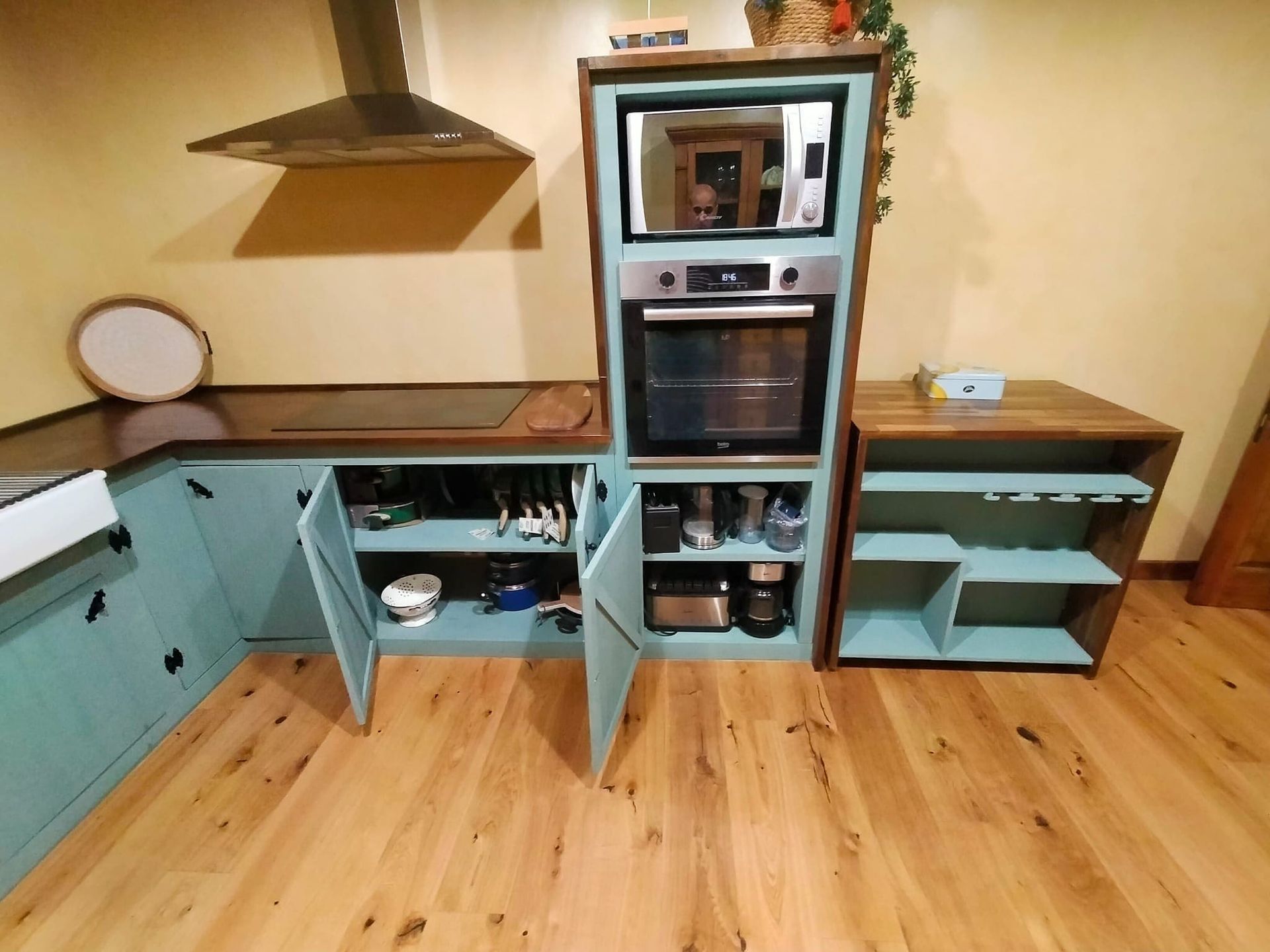 Una cocina con gabinetes azules y un horno de estufa.