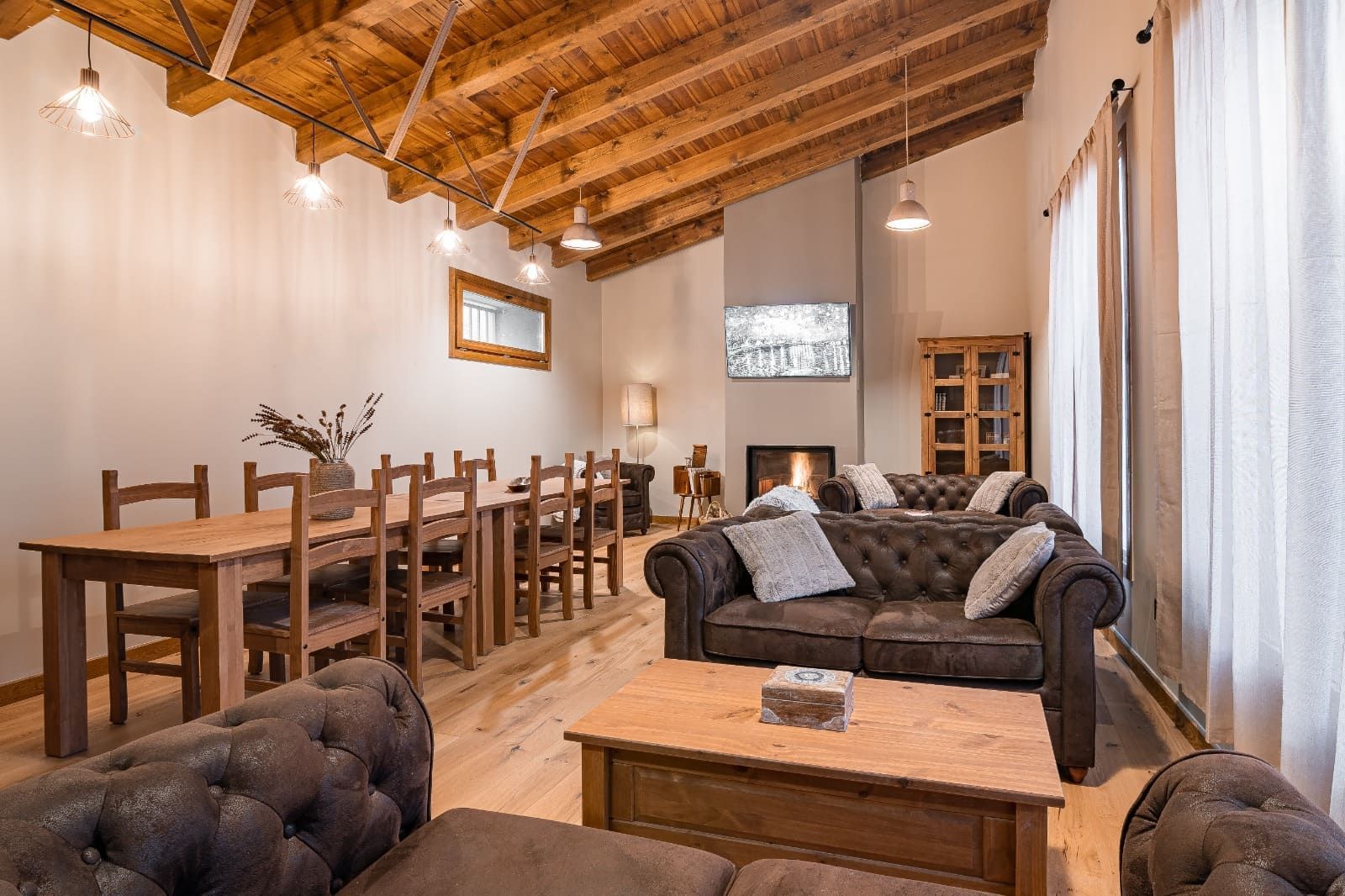 Una sala de estar con sofá, mesa, sillas y chimenea.