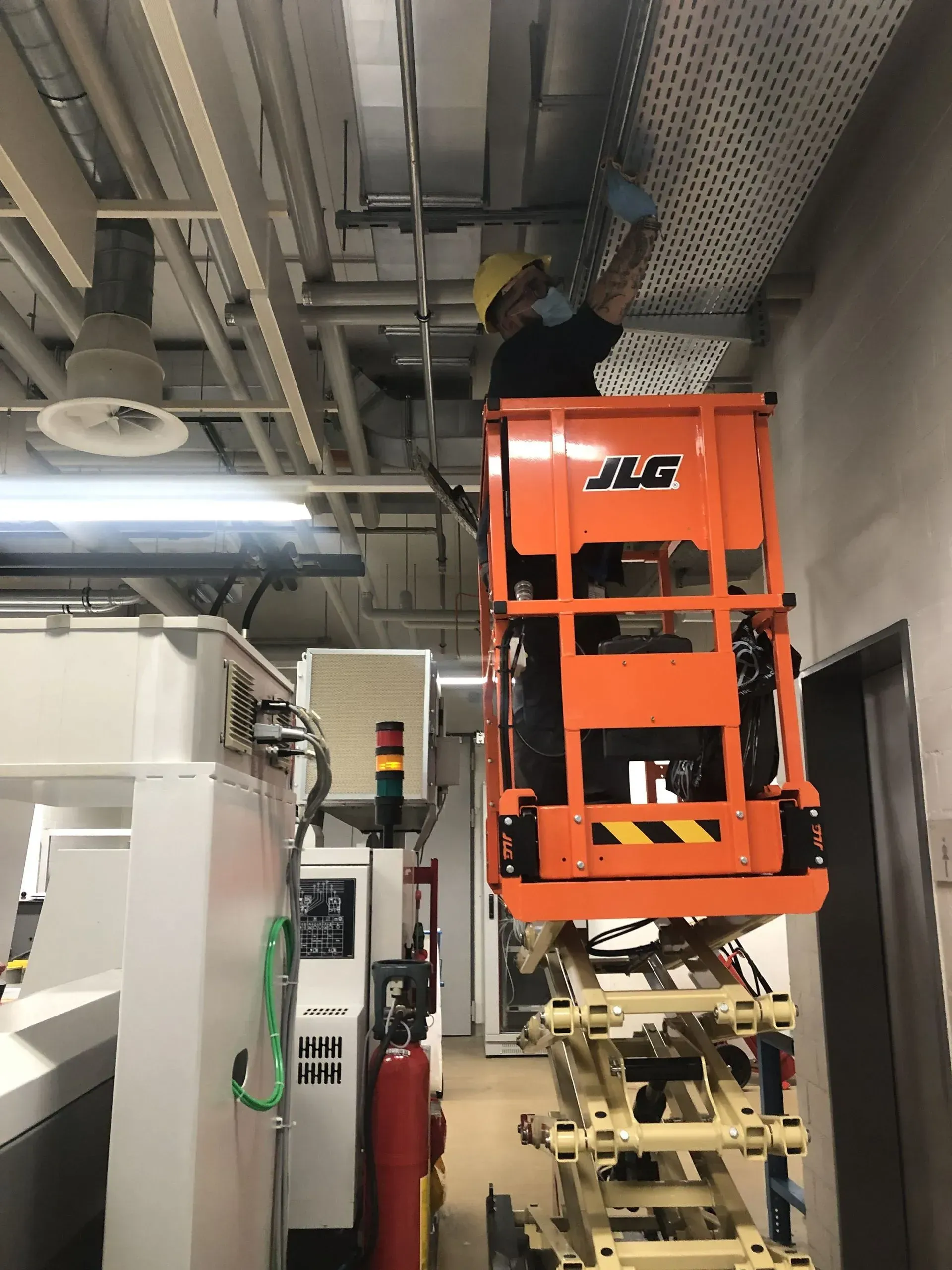 Un homme travaille sur un élévateur dans un entrepôt - KO Nettoyages Sàrl