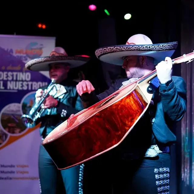 Un grupo de mariachis tocan violines y guitarras.