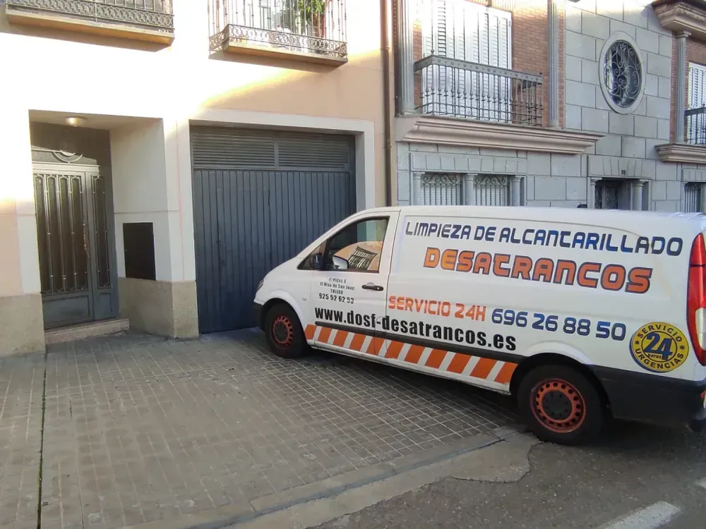 Una camioneta blanca está estacionada frente a un edificio
