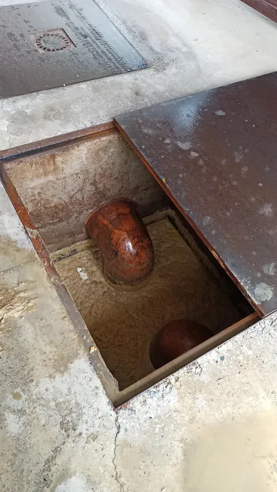 Un agujero en el suelo con una tapa de metal encima.