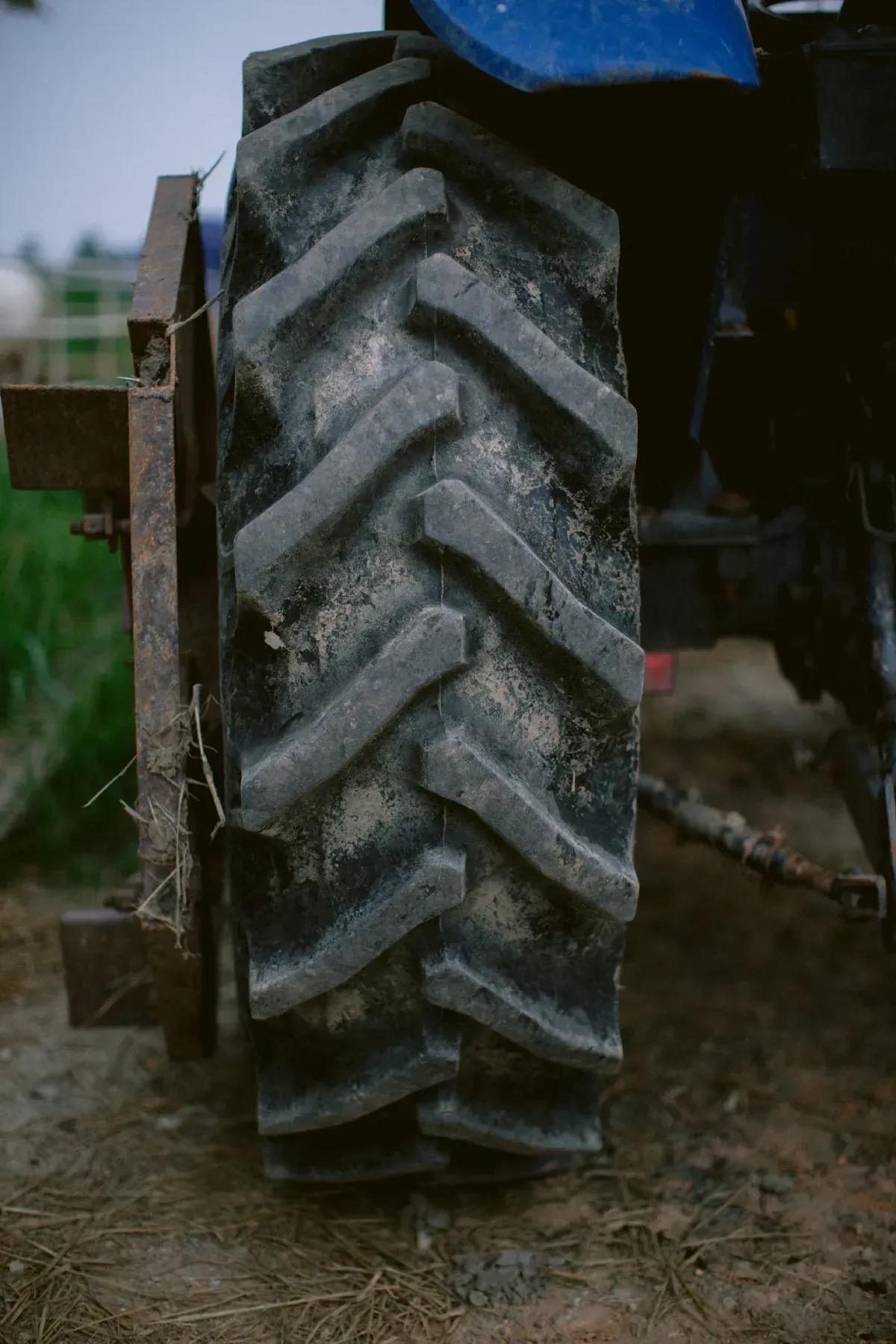 Coche rojo con una pila de neumáticos nuevos en un garaje.