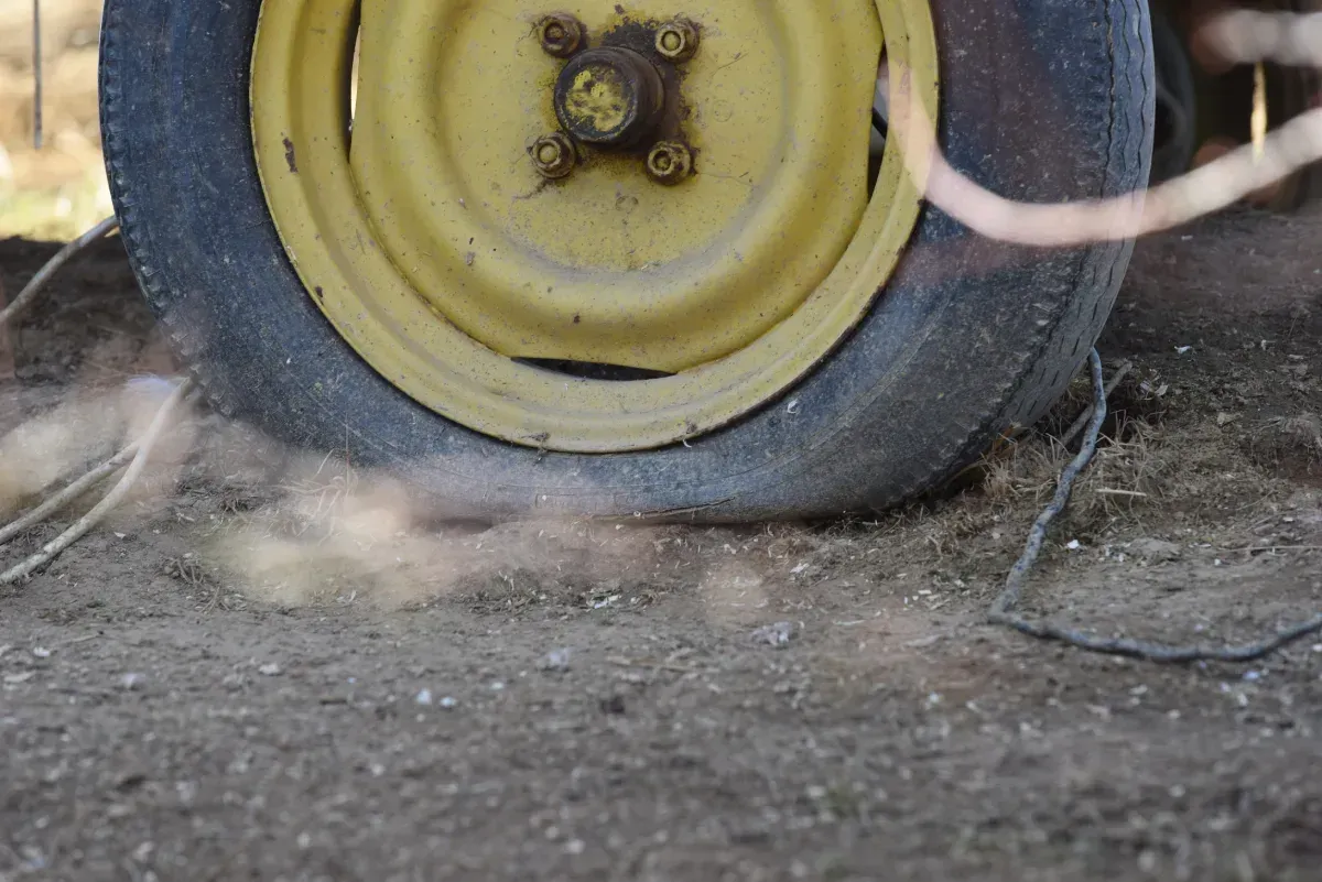 Furgoneta blanca con una pila de neumáticos negros delante, en el interior.