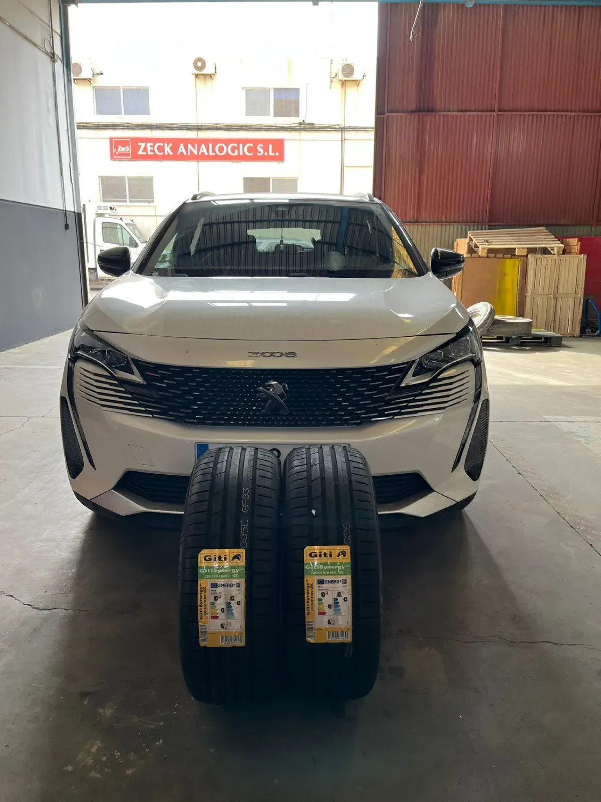 Todoterreno Peugeot de color blanco con dos neumáticos nuevos delante, dentro de un garaje.