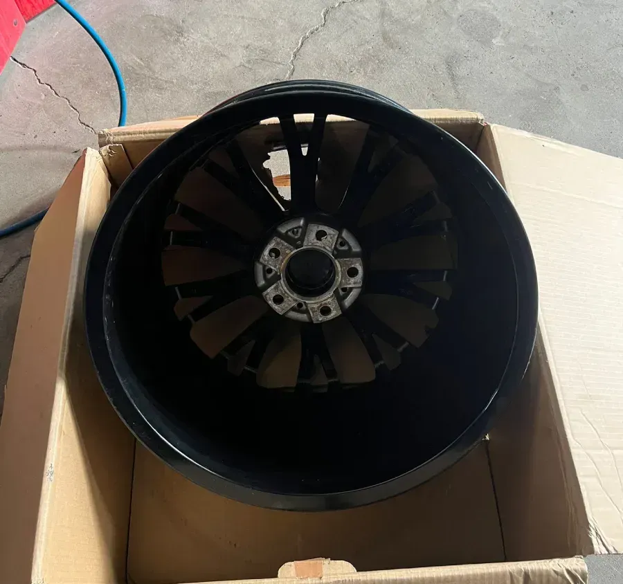 Rueda de coche negra dentro de una caja de cartón.