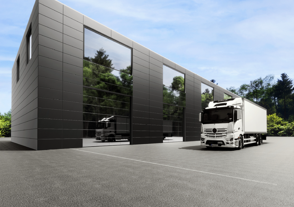 Schwarzes Metalldach auf einem hellen Backsteingebäude mit dunklem Schornstein.