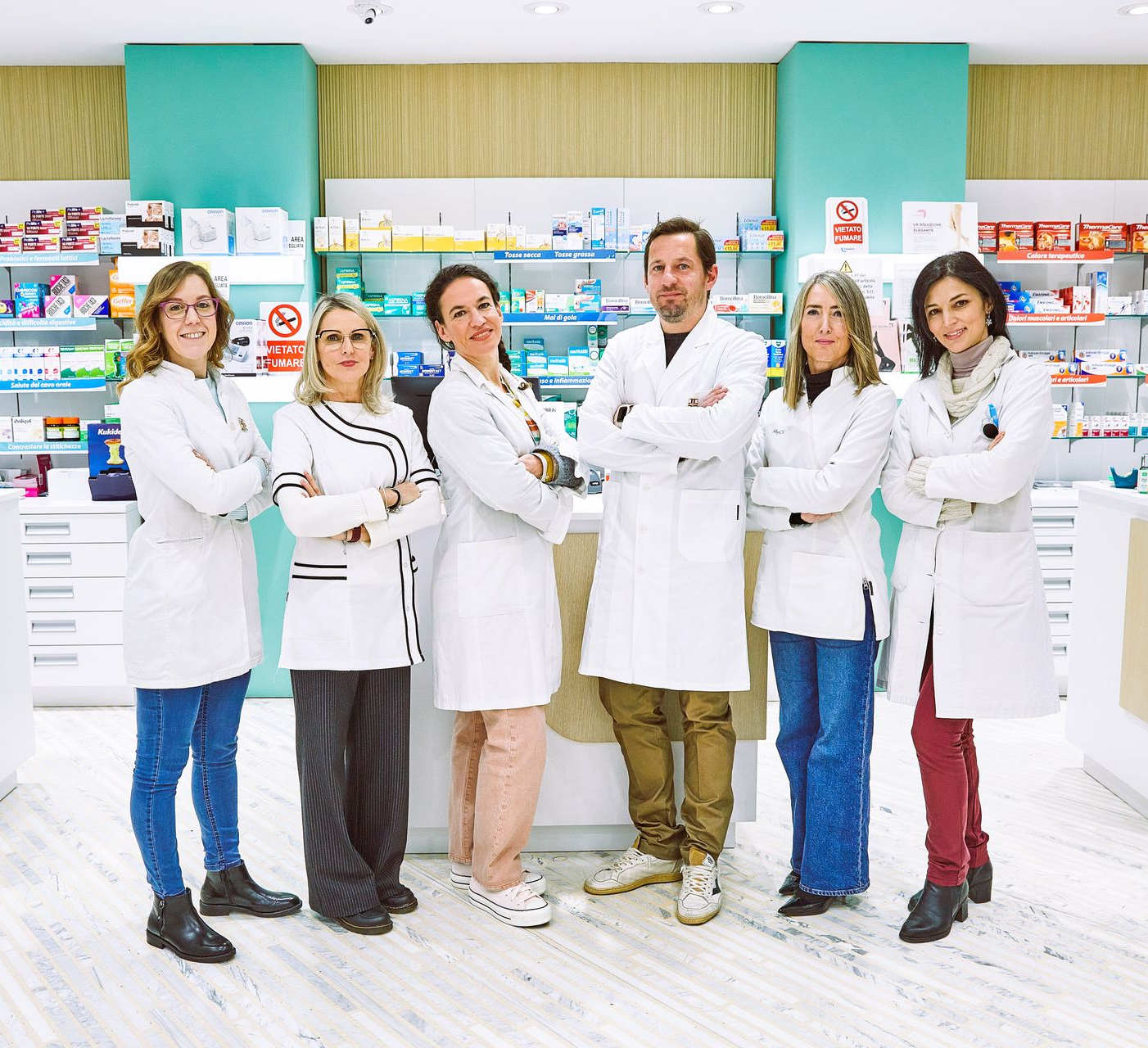 Staff della farmacia in piedi davanti al bancone, all'interno della farmacia