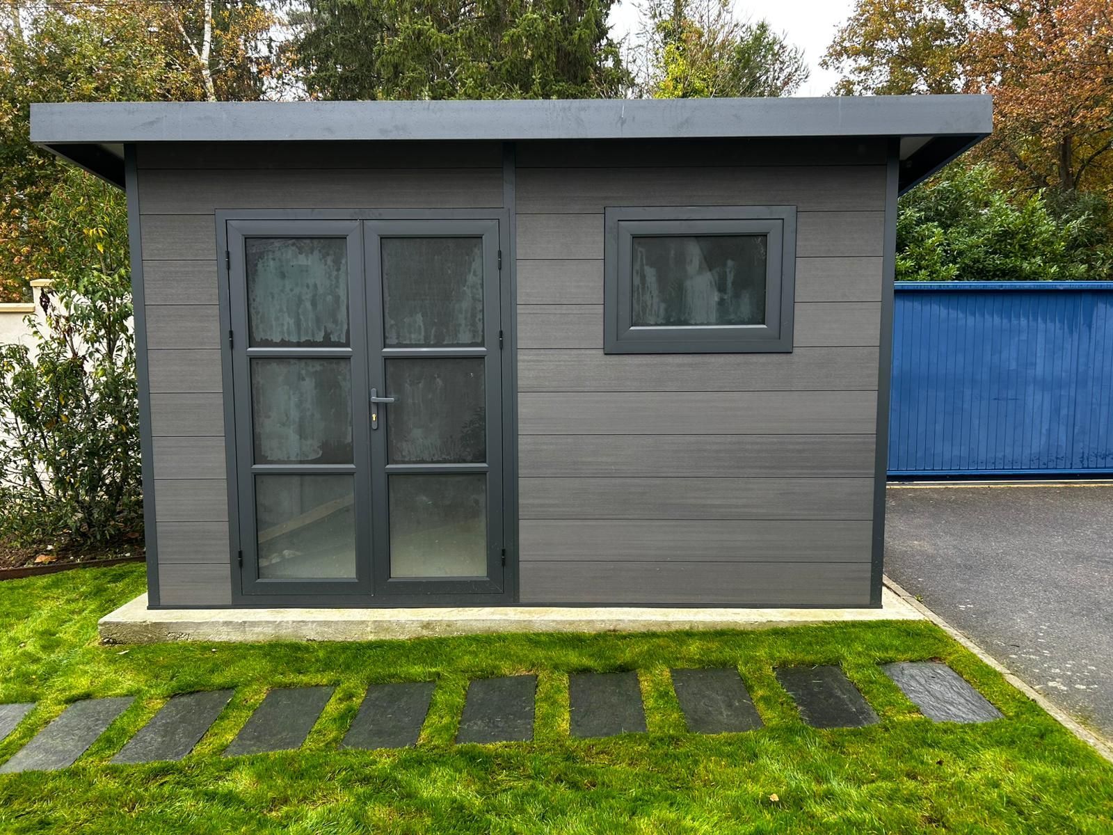 Service d'entretien des arbres : broyeur de branches, camion et ouvriers sur la pelouse.
