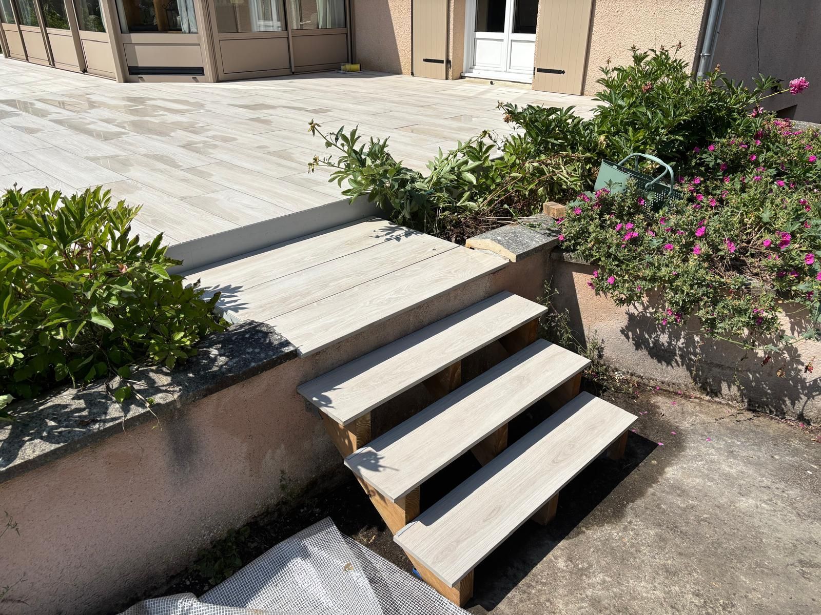 Une personne dans un arbre, utilisant une tronçonneuse. Ciel nuageux en arrière-plan, entouré de feuilles.