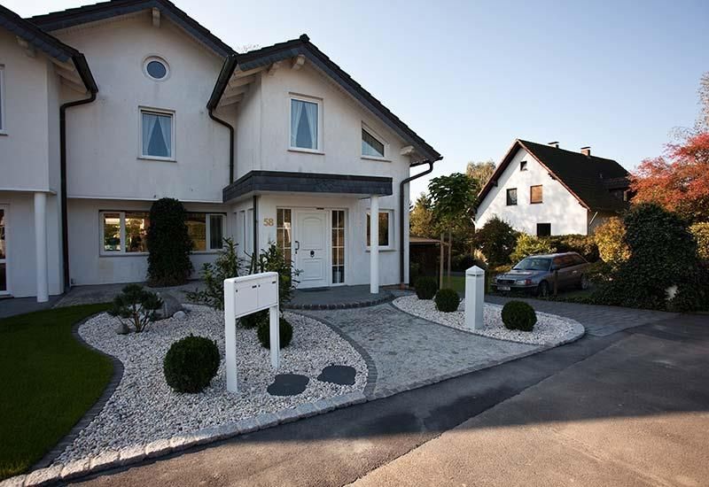 Ein weißes Haus mit einem davor geparkten Auto