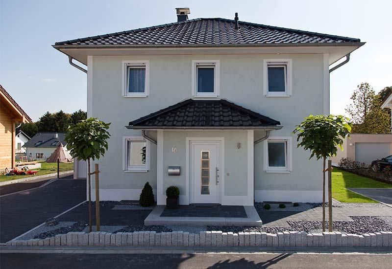 Ein Haus mit einem schwarzen Dach und einer weißen Tür