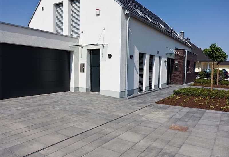 Ein weißes Haus mit einem schwarzen Garagentor