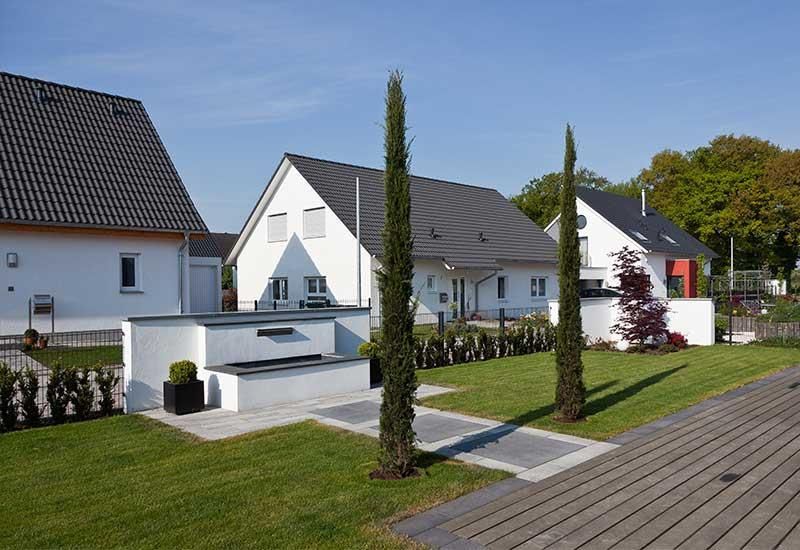 Eine Reihe weißer Häuser mit schwarzen Dächern stehen nebeneinander