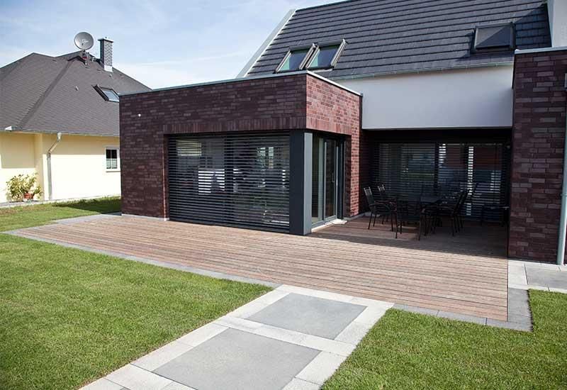 Ein Backsteinhaus mit einer Terrasse davor