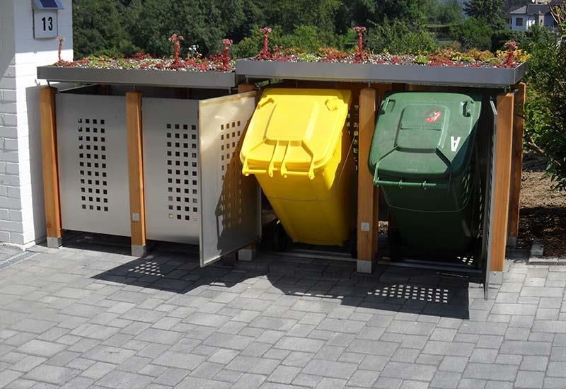 Eine Reihe von Mülltonnen stehen vor einem Schild mit der Aufschrift 13