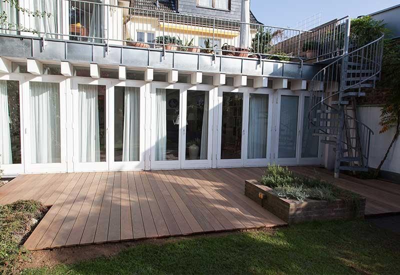 Ein Haus mit einer Holzterrasse und Treppen im Hinterhof