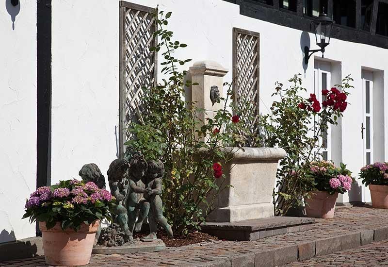 Ein weißes Gebäude mit Topfblumen davor