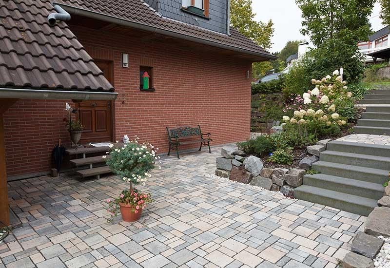 Ein Backsteinhaus mit einer Terrasse und einer Treppe davor