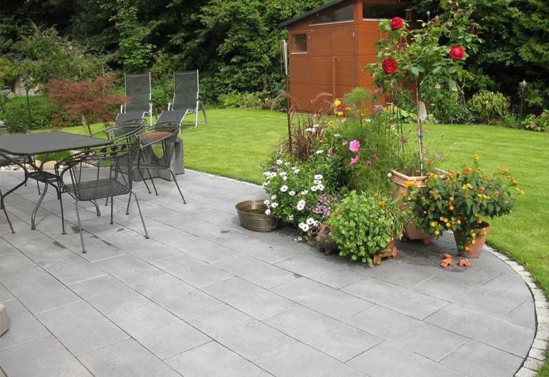 Eine Terrasse mit Tisch und Stühlen und Topfpflanzen