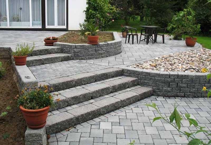 Eine Terrasse mit Treppen und Topfpflanzen vor einem Haus