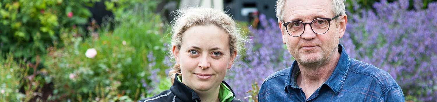 Ein Mann und eine Frau stehen nebeneinander in einem Garten.