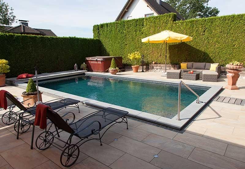 Ein großer Swimmingpool, umgeben von Stühlen und einem gelben Sonnenschirm