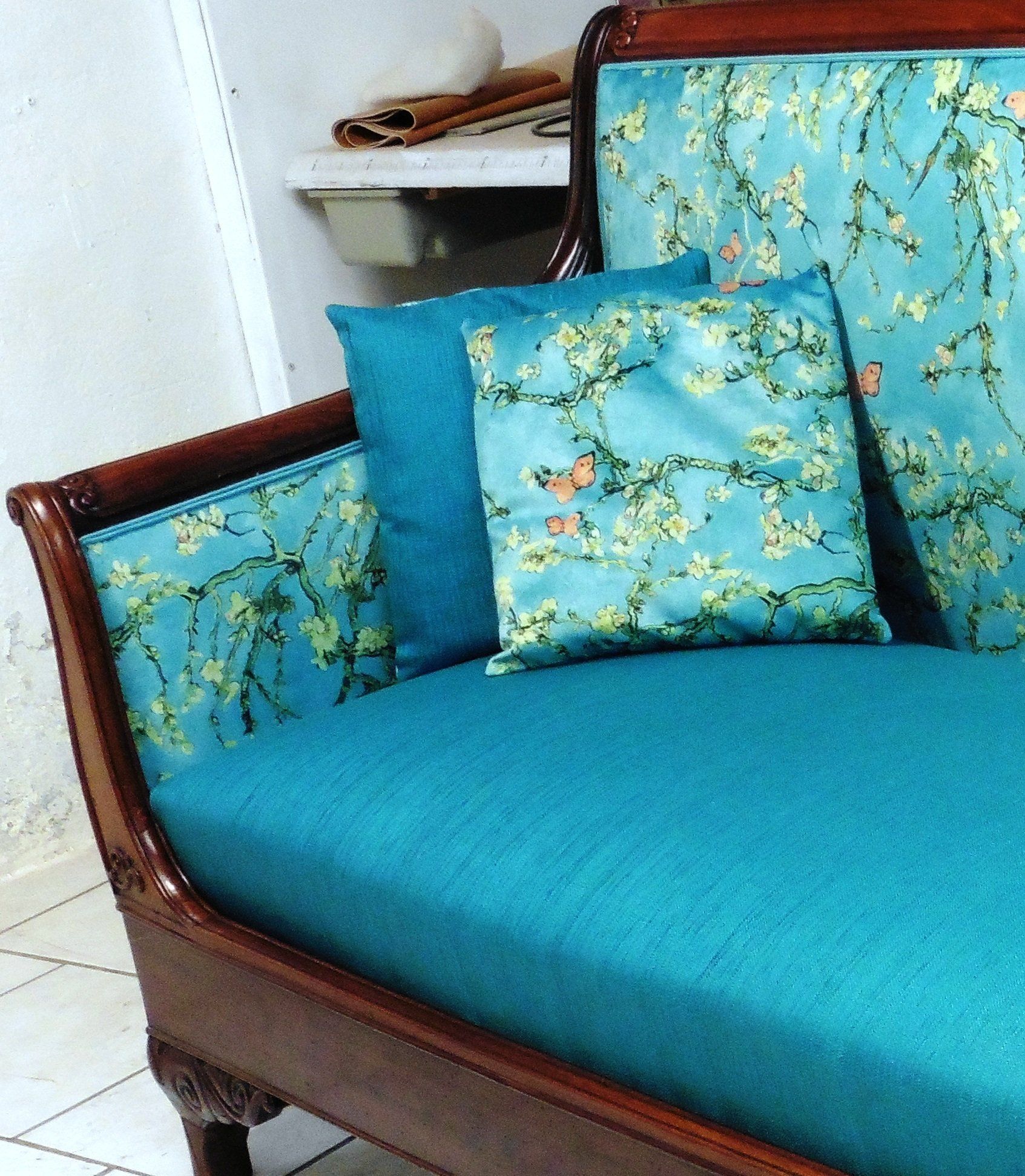 Canapé avec une structure en bois, revêtement en tissu bleu et deux coussins