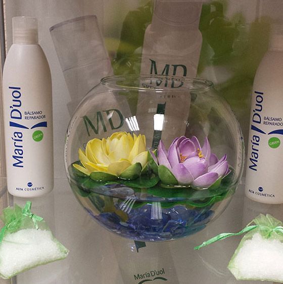 Dos botellas de Maria Duol están junto a un jarrón de flores.