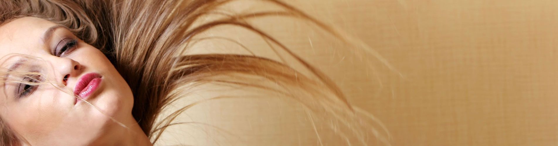 Una mujer con cabello largo está acostada en una cama.